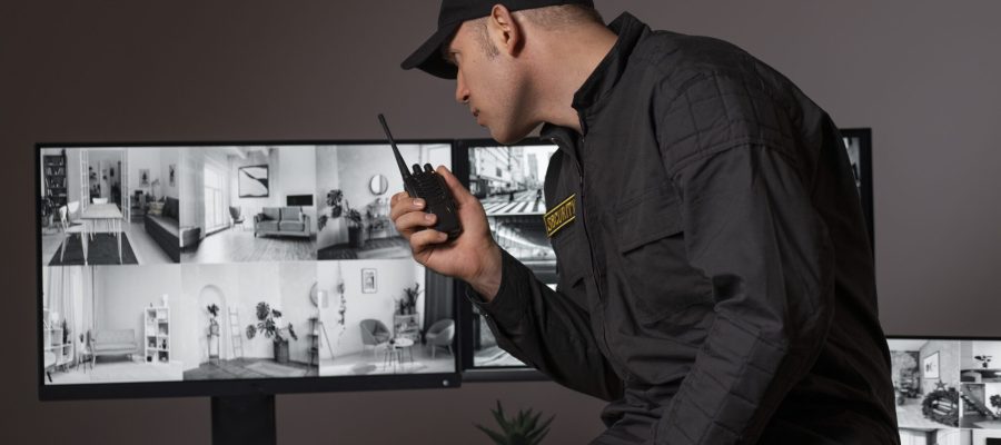 portrait-male-security-guard-with-radio-station-camera-screens